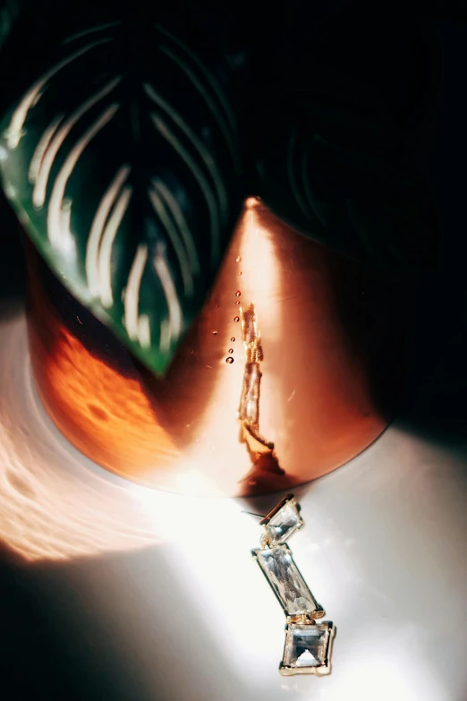 a close up of a person wearing a necklace, a photorealistic painting, inspired by Méret Oppenheim, unsplash, photorealism, copper cup, tropical lighting, cracking glass through reality, spilt coffee