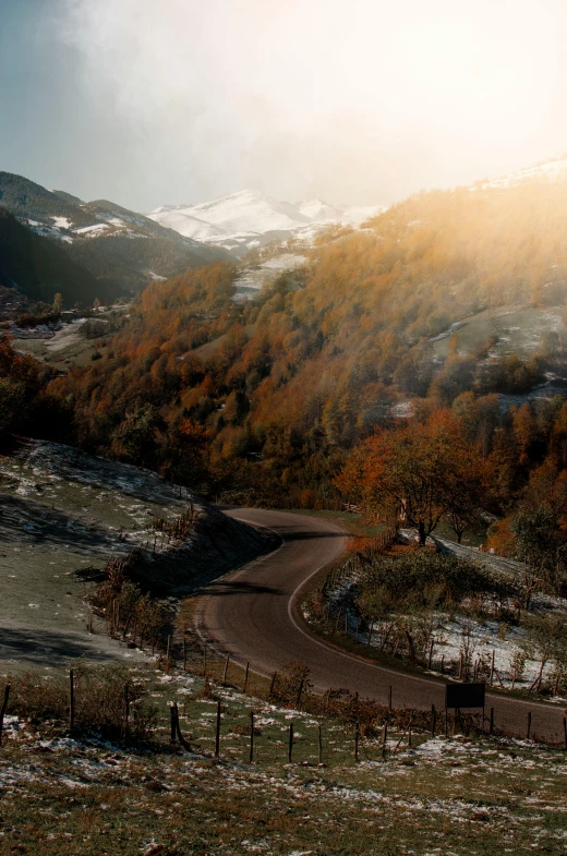 a person riding a horse down a snow covered road, pexels contest winner, renaissance, autumn mountains, 4 k cinematic panoramic view, serpentine curve!!!, in the golden hour