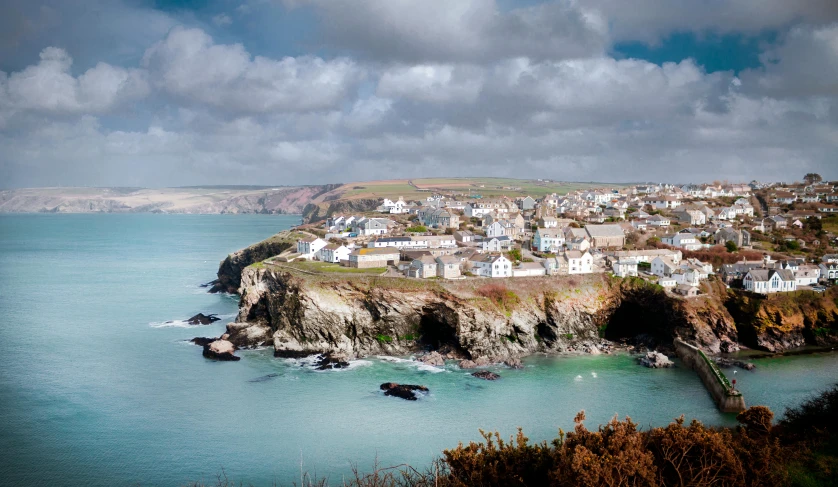 a town sitting on top of a cliff next to the ocean, pexels contest winner, cornwall, brown, sea - green and white clothes, panoramic