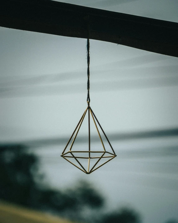 a close up of a light hanging from a ceiling, by Thomas Furlong, pexels contest winner, crystal cubism, pyramid surrounded with greenery, brass beak, vignette of windowsill, ultra detailed wire decoration