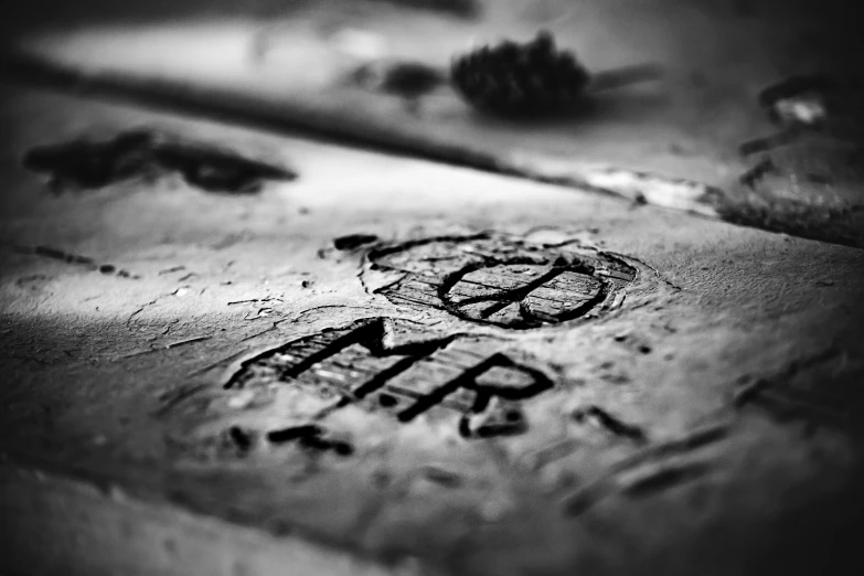 a black and white photo of graffiti on the ground, an etching, by Lucia Peka, unsplash, peace and love, miniature photography closeup, carving, cinematic. by leng jun