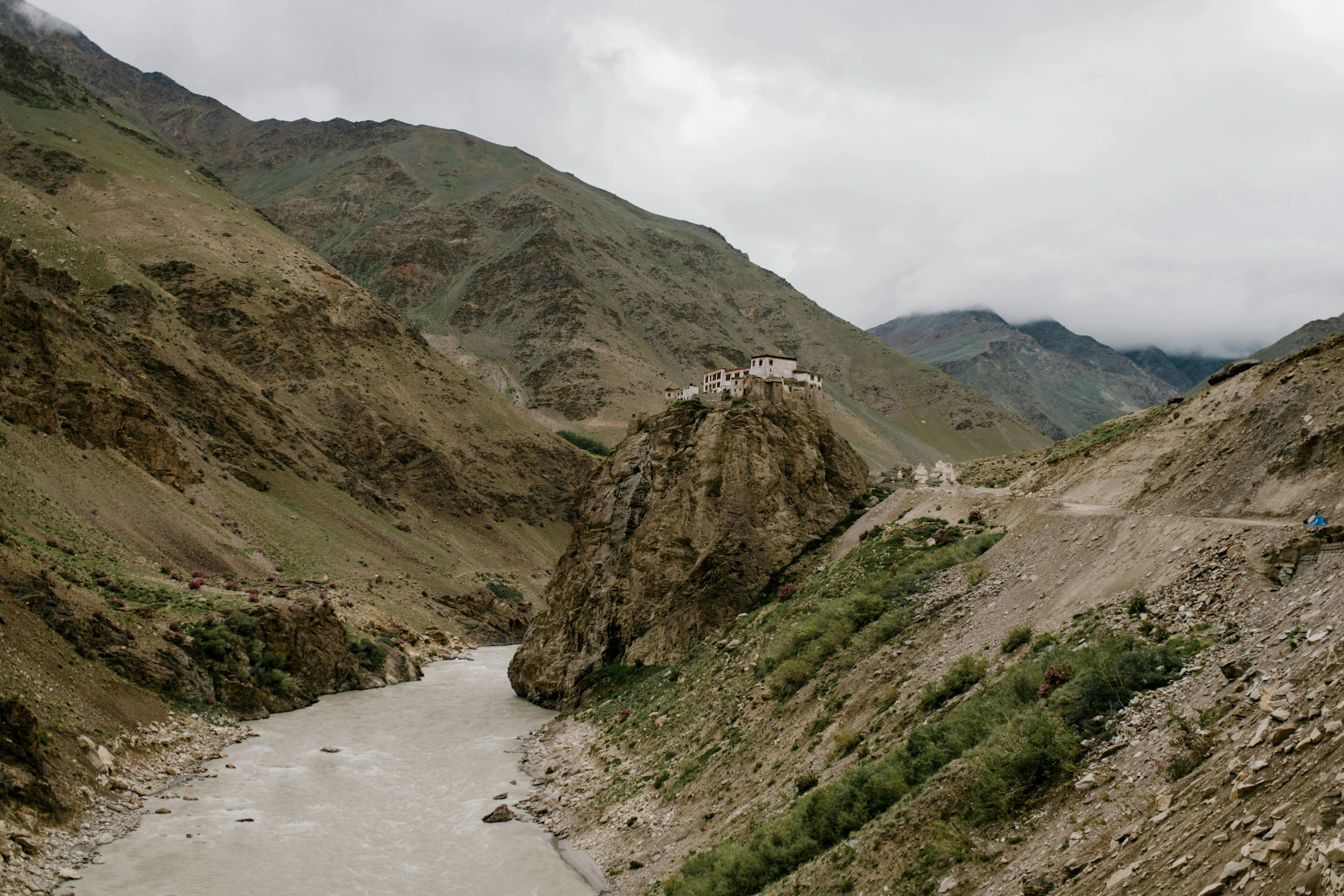 a river running through a valley next to a mountain, a portrait, pexels contest winner, hurufiyya, tibetan inspired architecture, nadav kander, wide high angle view, a cozy