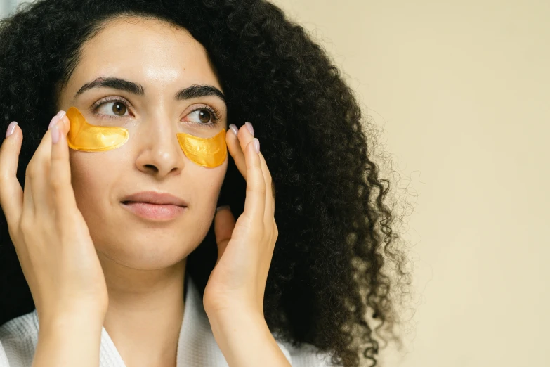 a woman with an orange peel on her face, trending on pexels, renaissance, eye patch over left eye, wavy hair yellow theme, middle eastern skin, manuka