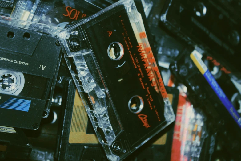 a pile of cassettes stacked on top of each other, inspired by Elsa Bleda, trending on pexels, goth aesthetic, grainy tape, thumbnail, performing