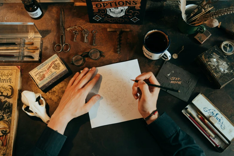 a person sitting at a table writing on a piece of paper, a drawing, pexels contest winner, gunsmithing, 9 9 designs, sailor jerry tattoo flash, crafting spells