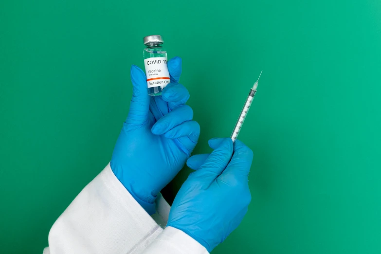 a person in a white coat and blue gloves holding a syll, syringe, a green, instagram post, 15081959 21121991 01012000 4k