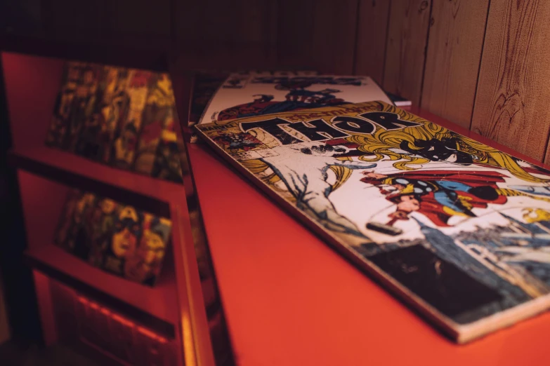 a book sitting on top of a red table, underground comix, thor, arcade machines, mcu photograph, thumbnail