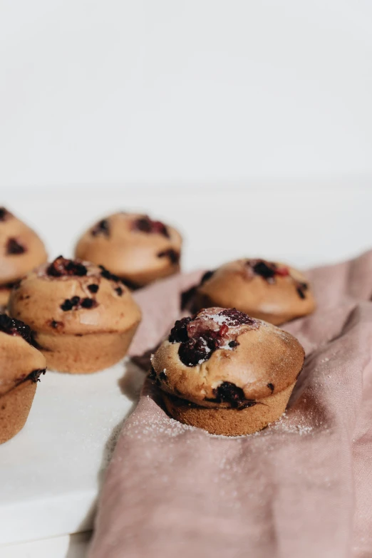 a person holding a plate with muffins on it, by Emma Andijewska, unsplash, hurufiyya, “berries, molten, full front view, brown