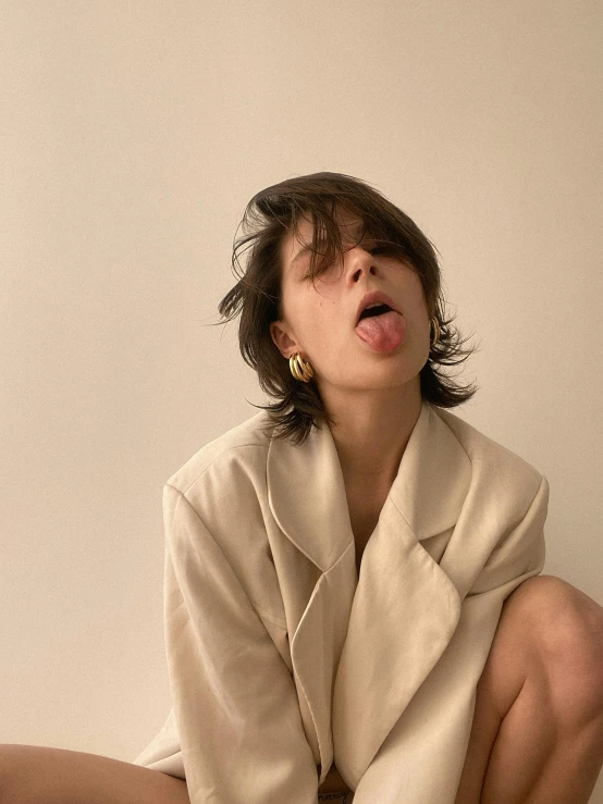 a woman sitting on a toilet with her mouth open, by Rebecca Horn, trending on unsplash, hyperrealism, tan suit, nishihara isao, cropped shirt with jacket, model エリサヘス s from acquamodels