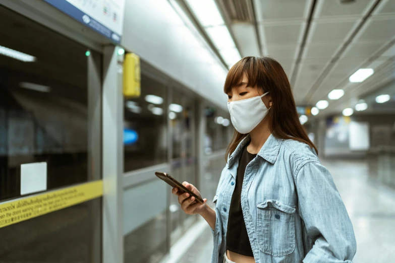 a woman wearing a face mask while looking at her phone, trending on pexels, underground metro, avatar image, square, south korean male