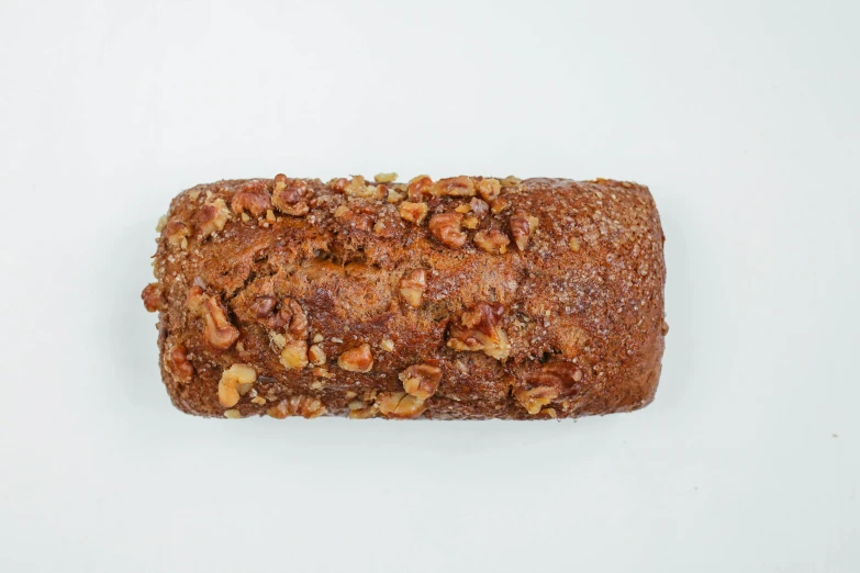 a loaf of bread sitting on top of a white surface, walnut wood, cake, detailed product image, frontal shot