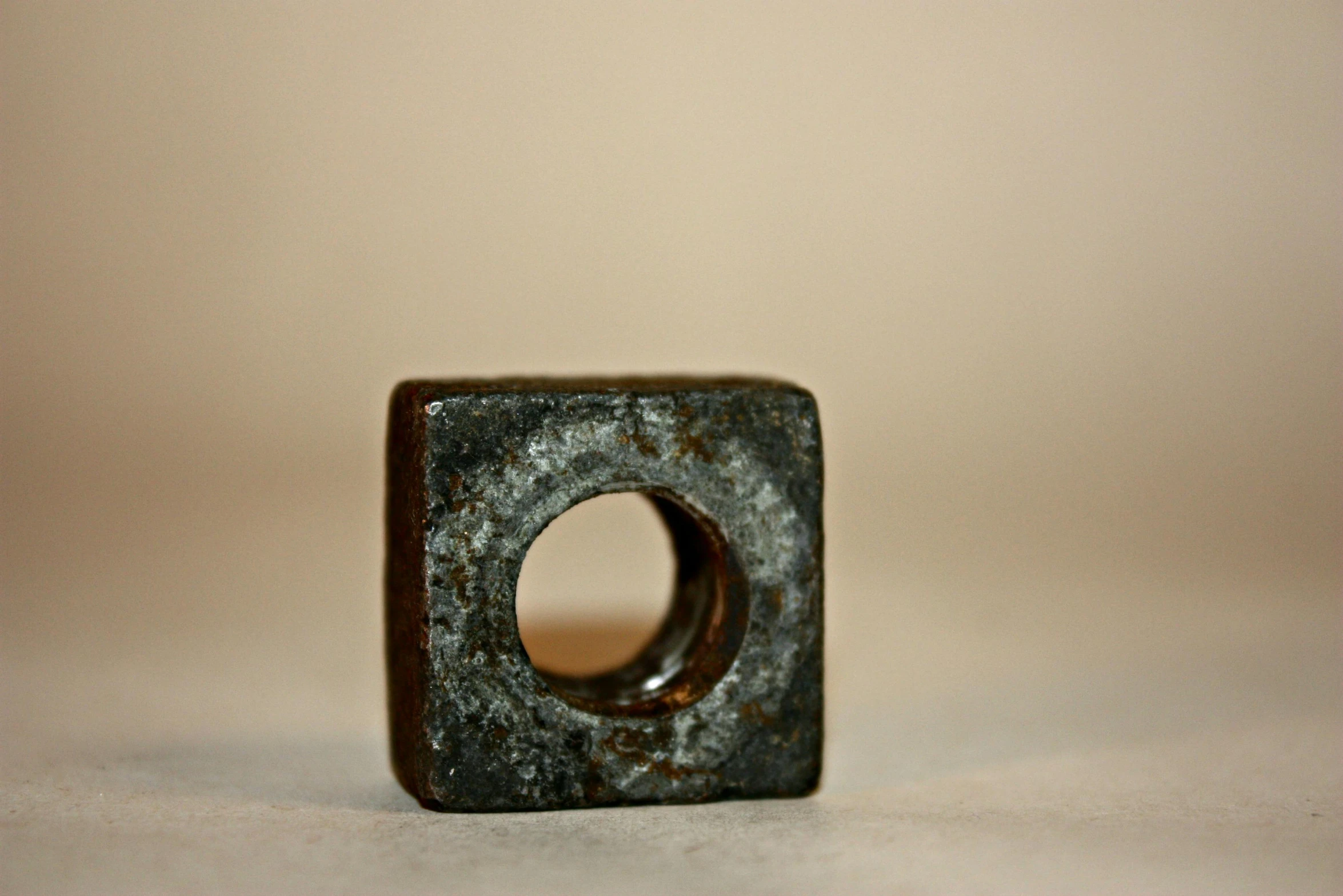 a close up of a metal object on a table, unsplash, cube portals, rusty, nut, detailed photograph high quality