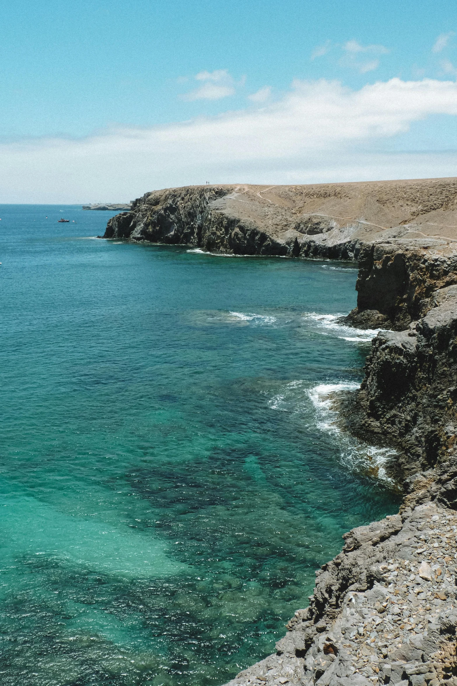 a man standing on top of a cliff next to the ocean, les nabis, few vivid turquoise highlights, conglomerate, beaches, walking to the right