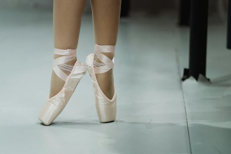 a close up of a pair of ballet shoes, an album cover, inspired by Elizabeth Polunin, shutterstock, arabesque, standing in class, thumbnail, candid shot, uncropped