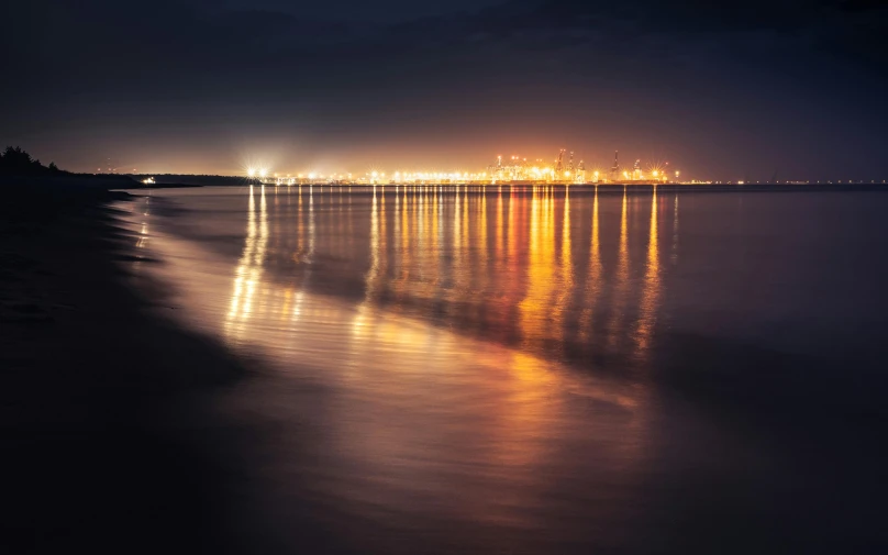 a beach at night with lights reflecting in the water, pexels contest winner, minimalism, distant cityscape, hull, furious lights, hazy