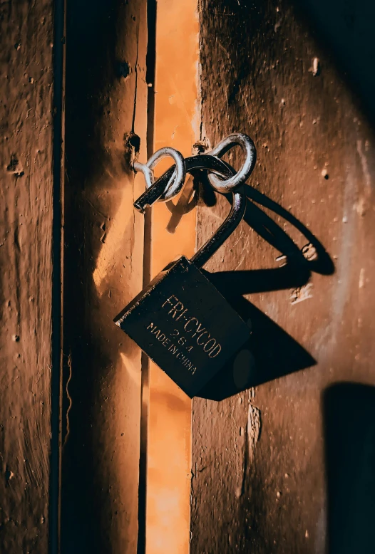 a book sitting on top of a wooden door, hook as ring, wrapped in black, engraved, dark themed