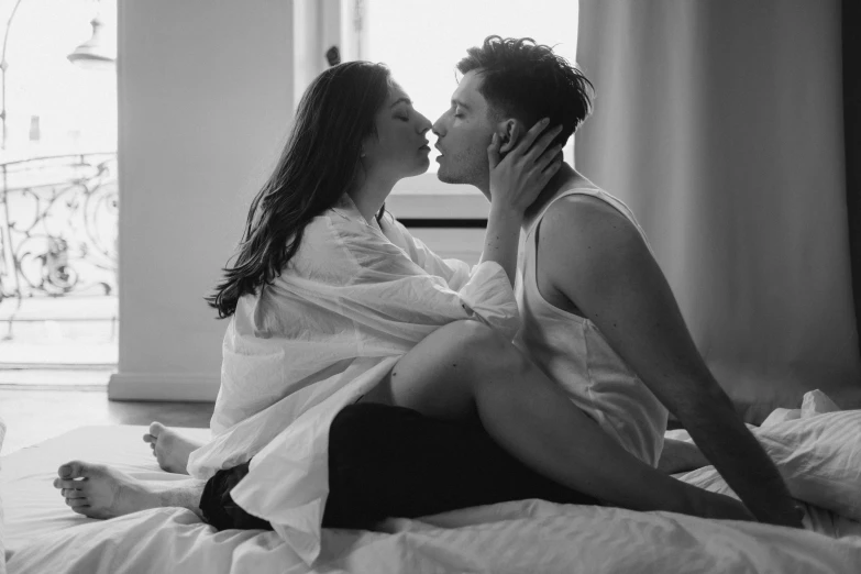 a man and a woman are sitting on a bed, a black and white photo, by Emma Andijewska, pexels, kisses are wordless spells, angela white, ariel perez, :: morning