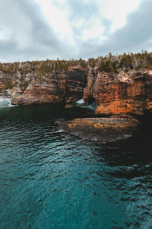 a large body of water next to a cliff, by Greg Rutkowski, pexels contest winner, les nabis, rock arches, archipelago, gigapixel photo, slide show