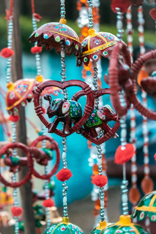 a close up of a bunch of beads, folk art, hanging lanterns, hearts, with kerala motifs, rides