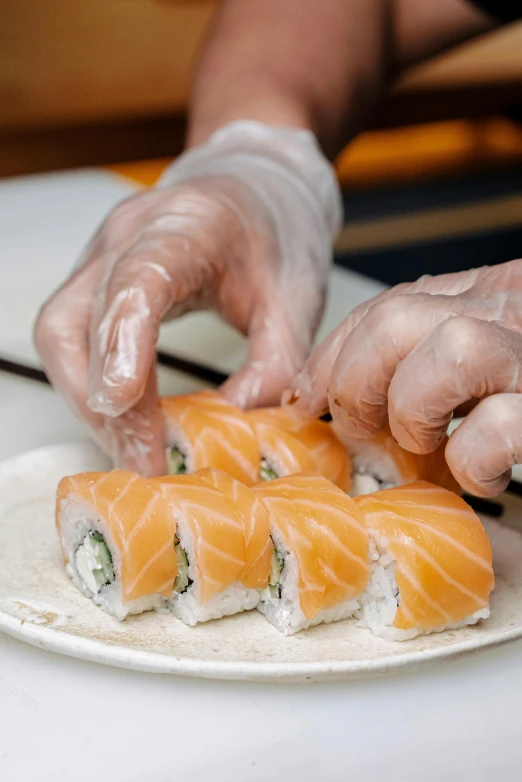 a person cutting a piece of sushi on a plate, curved blades on each hand, subtle detailing, highly upvoted, multiple stories