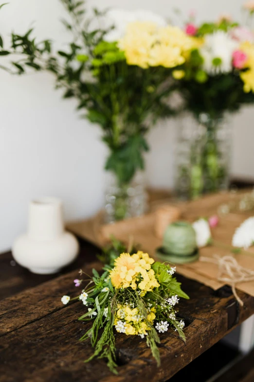 a bunch of flowers sitting on top of a wooden table, yellow details, displayed, product display photograph, carefully crafted