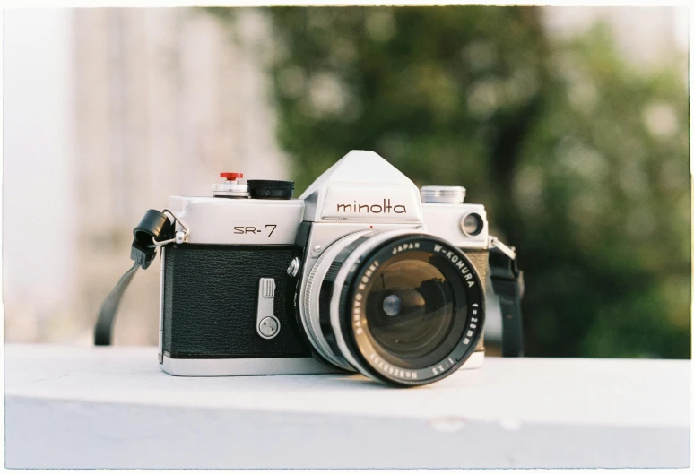 a camera sitting on top of a white table, inspired by Elsa Bleda, unsplash contest winner, photorealism, vintage soft grainy, konica minolta, fan favorite, taken in the late 1970s