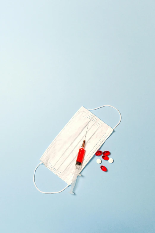 a medical mask and pills on a blue background, by Andries Stock, iv pole, white red, on a white table, product image