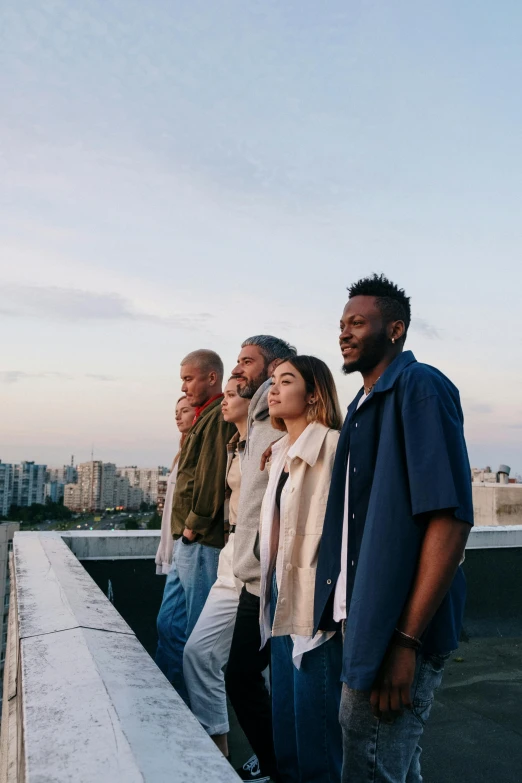 a group of people standing on top of a building, pexels contest winner, looking to the side off camera, millennial vibes, heavenly, four stories high