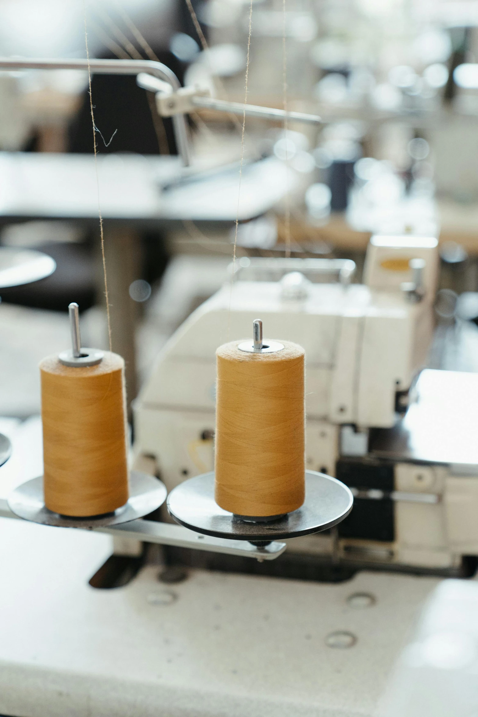 a close up of two spools of thread on a machine, trending on pexels, renaissance, tall factory, overlooking, thumbnail, brown