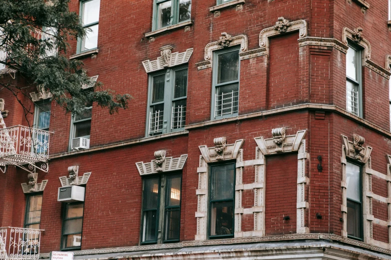 a tall red brick building sitting on the side of a street, by Nina Hamnett, pexels contest winner, art nouveau, harlem, maroon and white, stone facade, background image