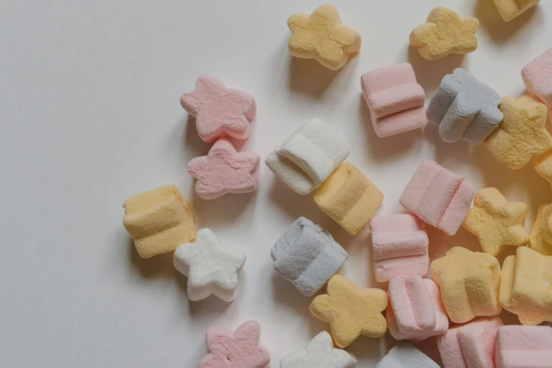 a pile of marshmallows on a white surface, inspired by Ödön Márffy, pexels contest winner, les nabis, tiny stars, vintage shapes, background image