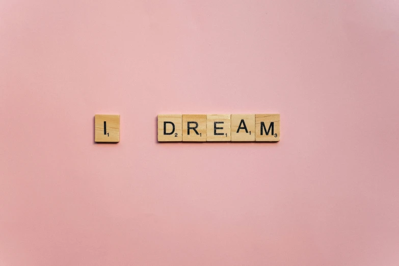 scrabbles spelling i dream on a pink background, by Bernie D’Andrea, pexels, aestheticism, wall art, ! dream, dreamy kodak color stock, a wooden
