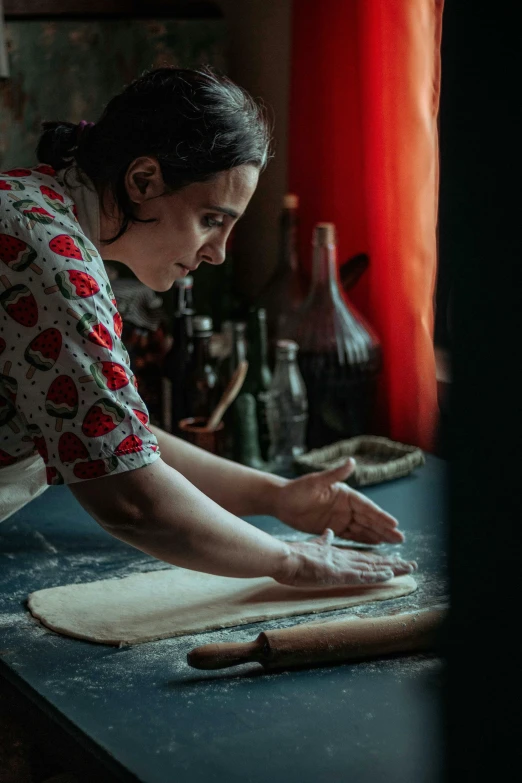 a woman rolling out dough on a table, a portrait, by Julia Pishtar, pexels contest winner, thumbnail, performance, woman is curved, profile