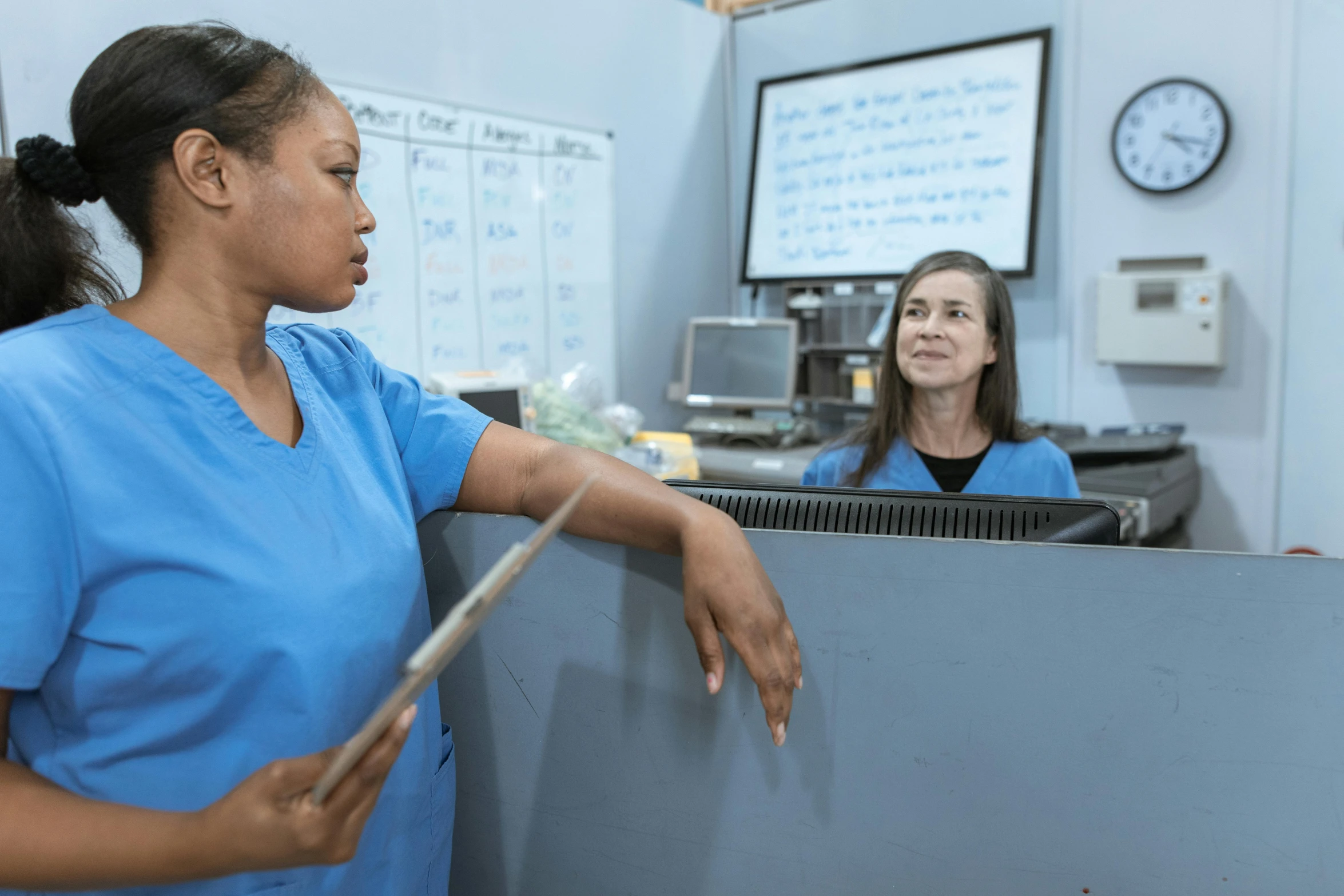 a woman in a blue scrub suit holding a clipboard, by Dan Frazier, happening, woman holding another woman, in a lab, profile image, trending photo