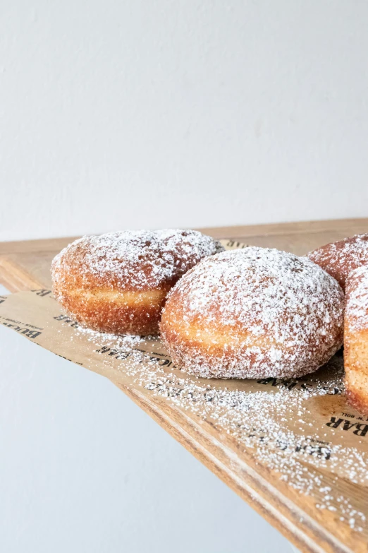a table topped with three donuts covered in powdered sugar, 6 pack, crisp smooth clean lines, handcrafted, bixbite
