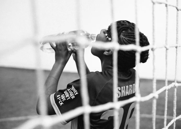 a black and white photo of a person drinking water, soccer player, sharpe focus, maria borges, netting