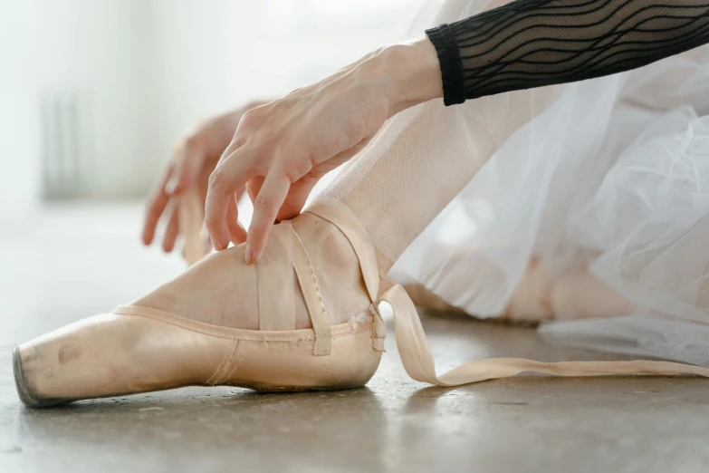 a ballerina tying up her ballet shoes, by Elizabeth Polunin, trending on pexels, arabesque, thumbnail, creamy, still frame, smooth surface