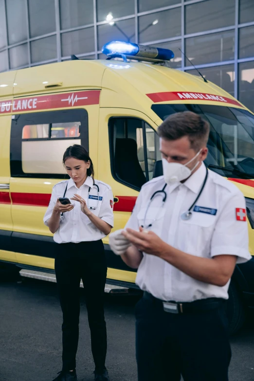 a group of people standing in front of a yellow ambulance, by Adam Marczyński, pexels, checking her cell phone, nurse scrubs, russian, inspect in inventory image