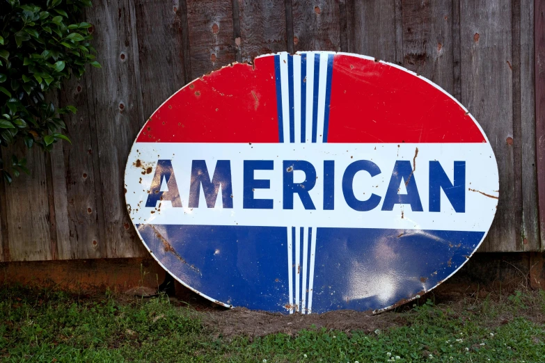 a red, white and blue american gas sign in front of a wooden fence, inspired by Americo Makk, antiques, round-cropped, ebay listing thumbnail, ancient