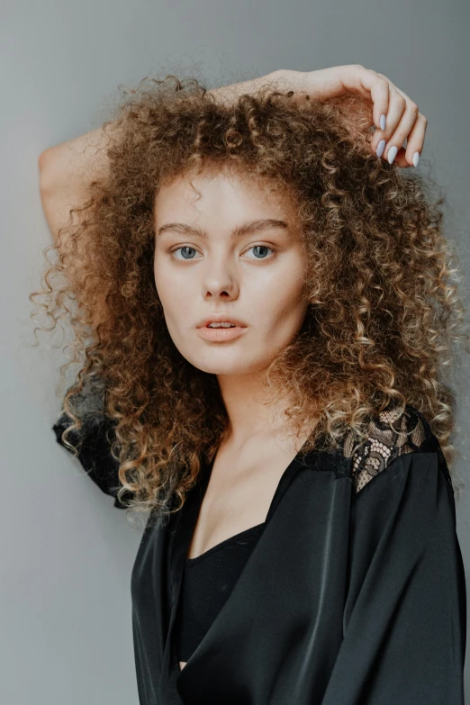 a woman with curly hair posing for a picture, dasha taran, high textured, mixed styles, zoomed in