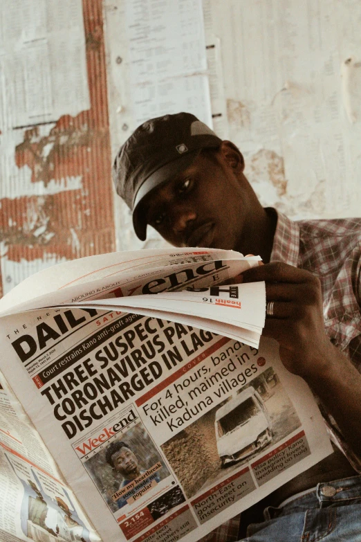 a man sitting on a couch reading a newspaper, a picture, pexels contest winner, private press, somalia, portrait of tall, press paparazzi photograph, adut akech