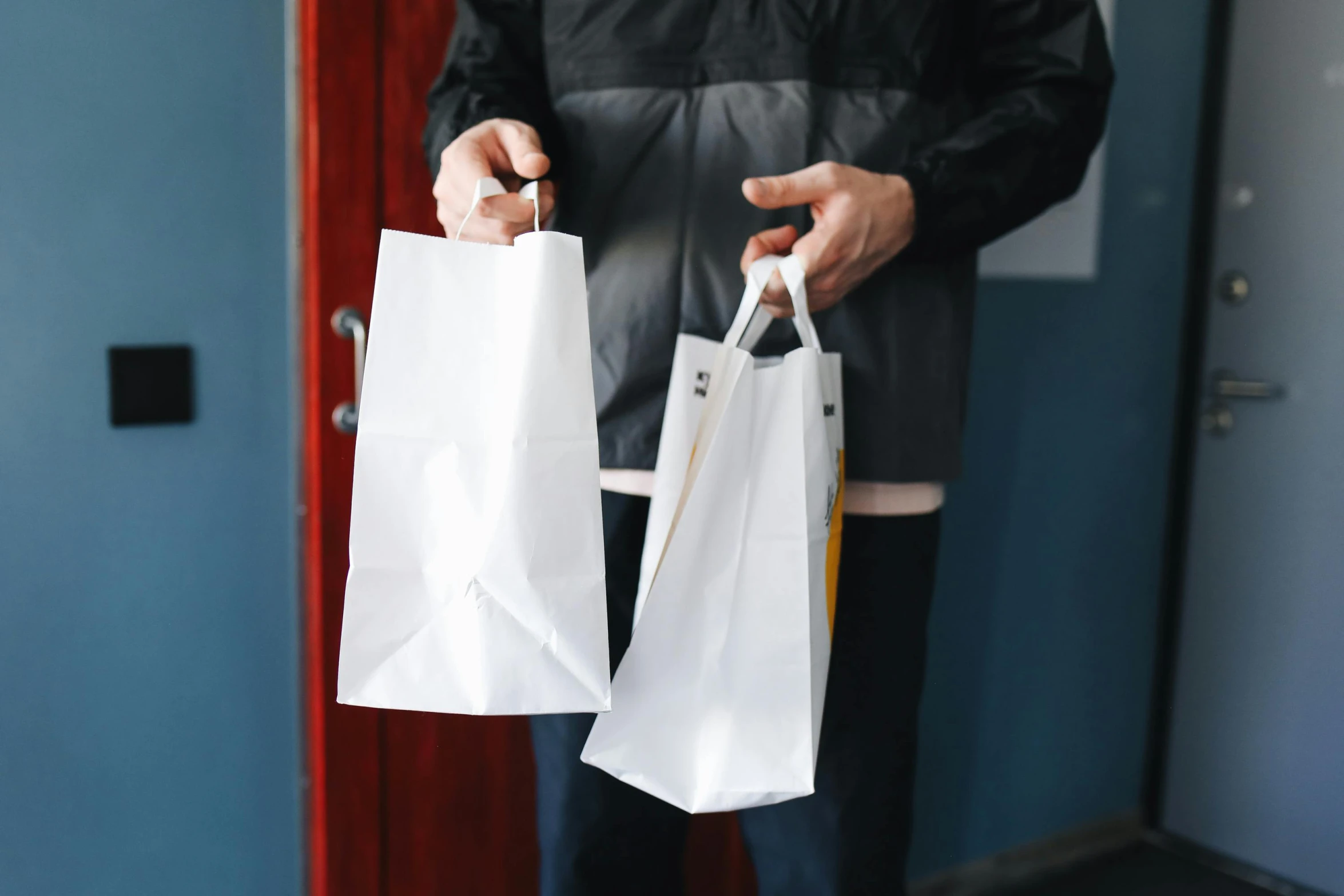 a person holding two white bags in their hands, pexels contest winner, private press, fast food review, shop front, made from paper, diecut