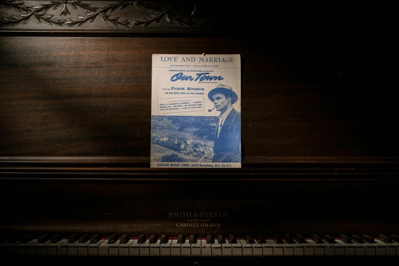 a book sitting on top of a piano, advertising photograph, old hollywood, love theme, ori toor