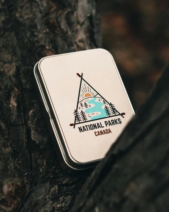 a metal tin sitting on top of a tree, product image, badge, national geographic quality, high quality image