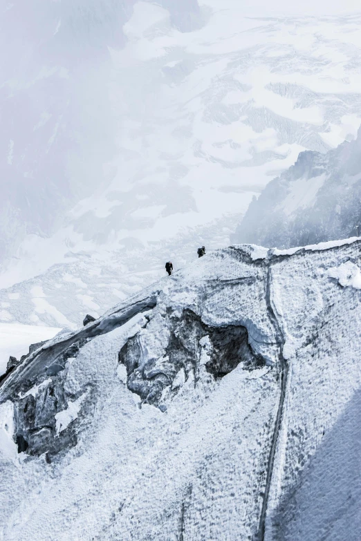 a group of people standing on top of a snow covered mountain, inspired by Peter Zumthor, pexels contest winner, extreme details, looking down a cliff, nepal, alvaro siza