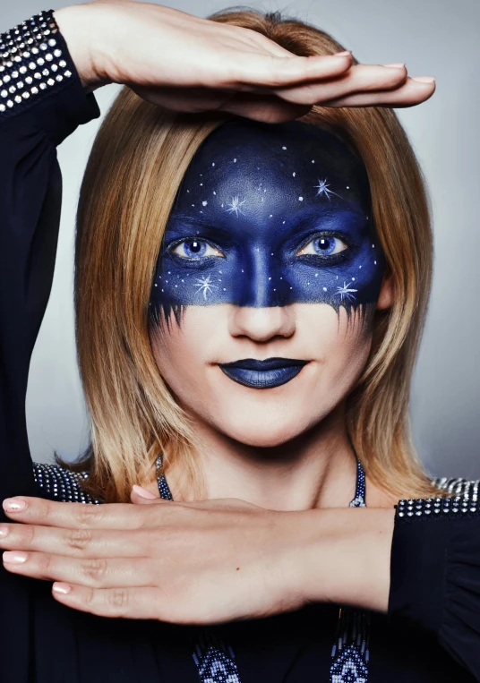 a woman with blue paint on her face, an album cover, inspired by Julia Pishtar, trending on pexels, starry, navy-blue, face painting, rectangle