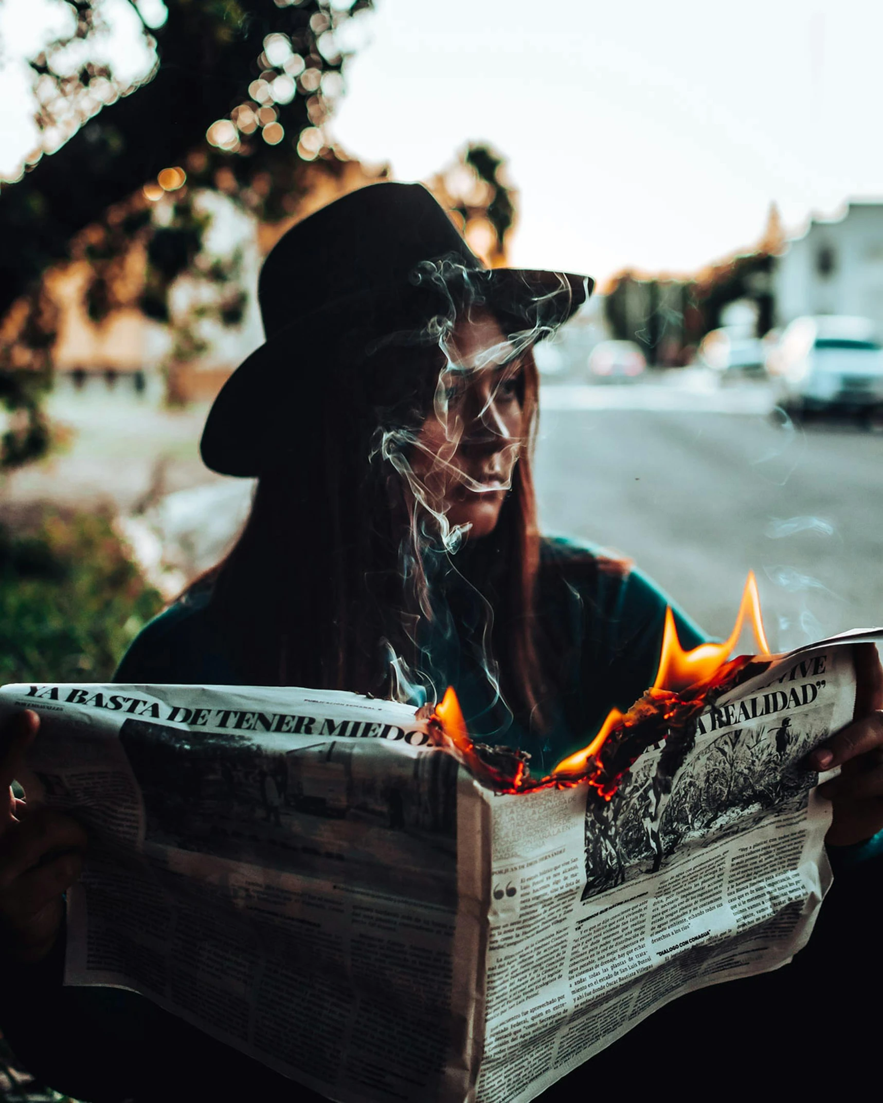 a person sitting on a bench reading a newspaper, by Emma Andijewska, unsplash contest winner, surrealism, witch burning, smug look, bushfire, photo of the girl