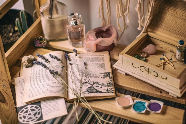 an open book sitting on top of a wooden table, a still life, trending on pexels, arts and crafts movement, magical potions, violet and pink palette, lots of jars and boxes of herbs, an escape room in a small