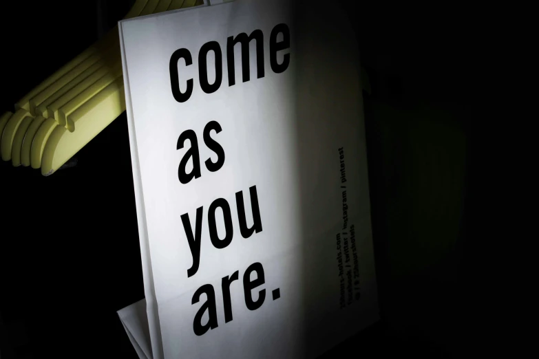 a sign that says come as you are, a poster, by Matija Jama, ap, ( ( ( in a dark, lightbox, book