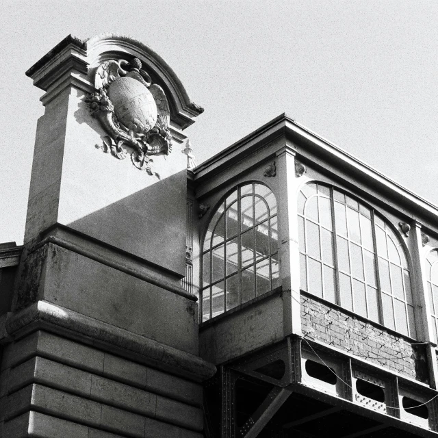 a black and white photo of a building with a clock, inspired by Alexandre Falguière, paris school, biennale, balcony, pavilion, left profile